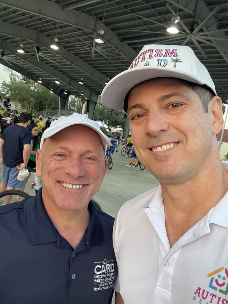 Victor Antunez and UM-CARD Executive Director smiling together at the autism action bike ride in Doral, Florida.