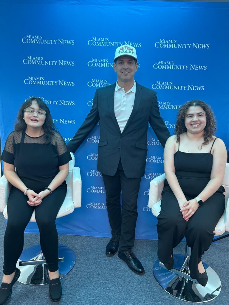 Miami Autism Dad Victor Antunez stands for a photo with autistic violin duo SofistyKat Strings.