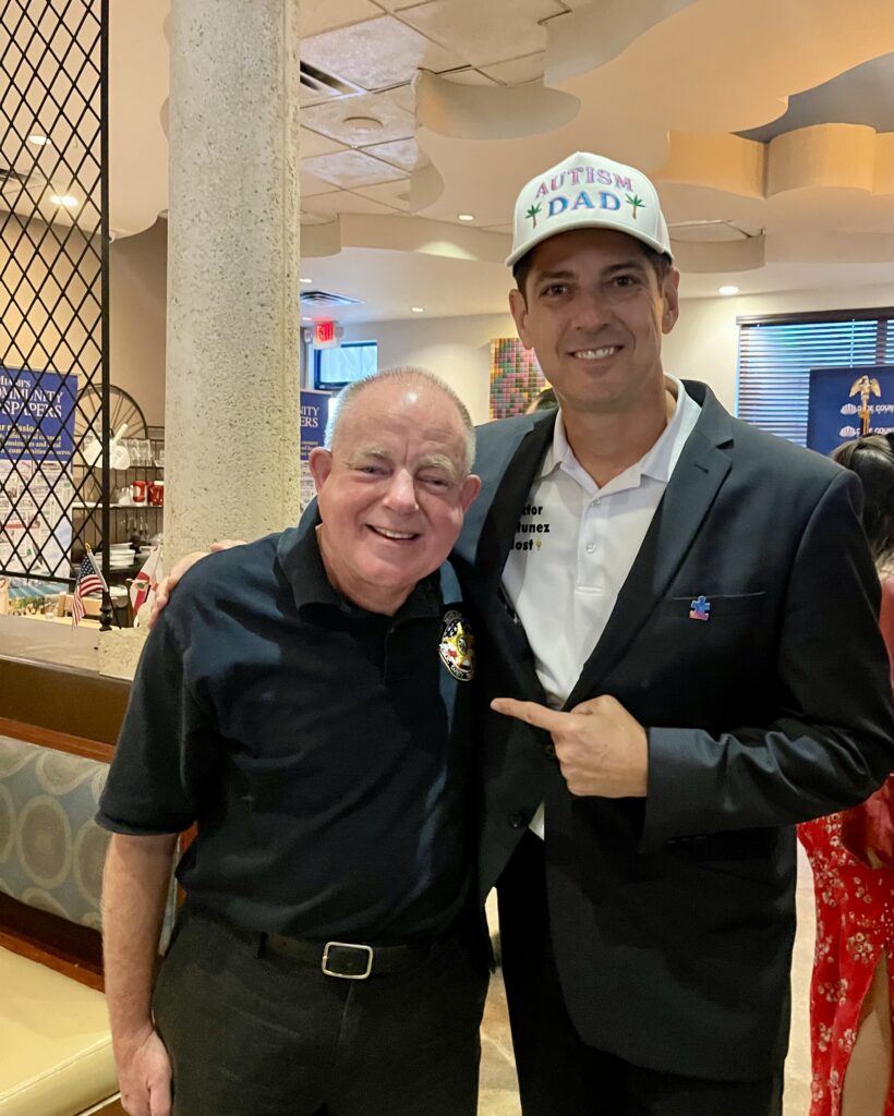 Kent Schomber and Miami Autism Dad Victor Antunez smiling for a photo at a community event.